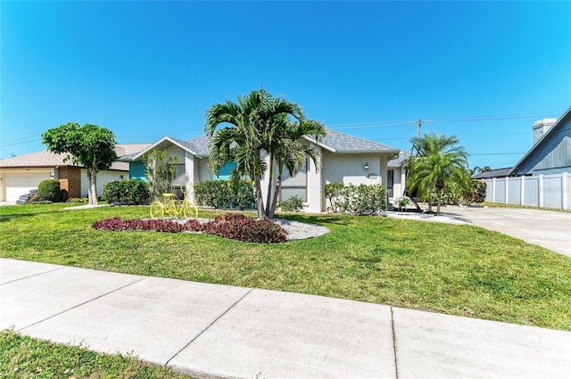 ranch-style house featuring fence, stucco siding, and a front yard