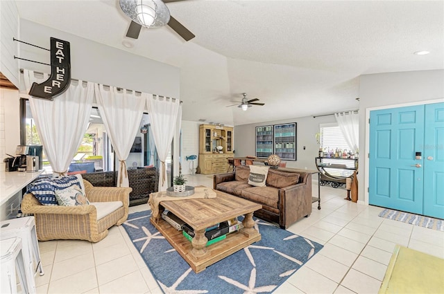 living area featuring light tile patterned flooring, ceiling fan, plenty of natural light, and lofted ceiling