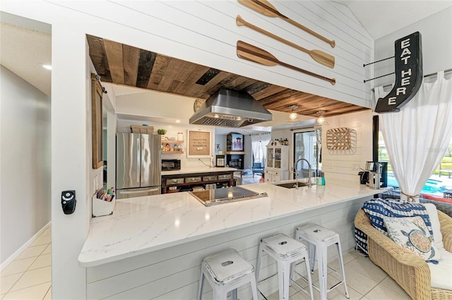 kitchen with freestanding refrigerator, exhaust hood, tile patterned floors, and electric cooktop