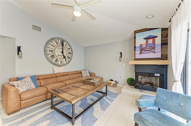 tiled living room featuring a textured ceiling, vaulted ceiling, and visible vents