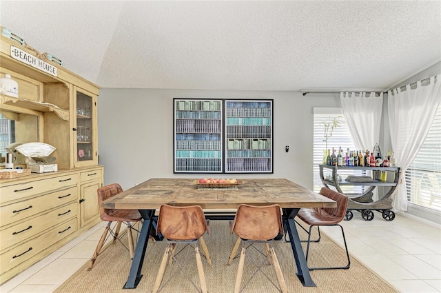 dining area featuring a textured ceiling and light tile patterned flooring