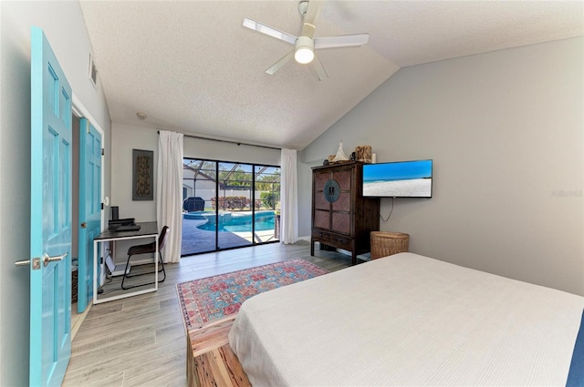 bedroom with a textured ceiling, access to exterior, and light wood-style floors