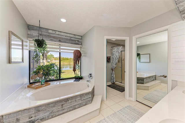 bathroom featuring a garden tub, a textured ceiling, tile patterned flooring, and vanity