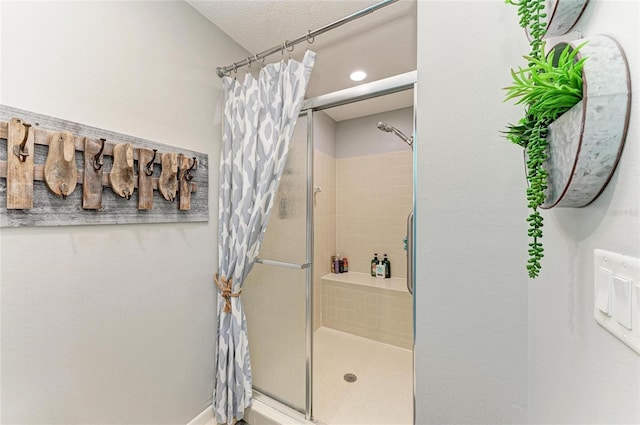 bathroom featuring a shower stall and a textured ceiling