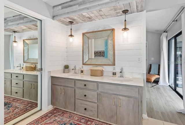 bathroom with double vanity, a sink, and wood walls
