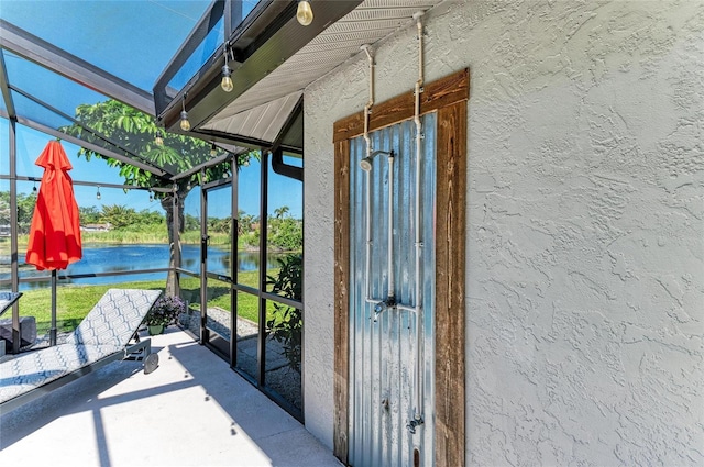property entrance with a water view and stucco siding