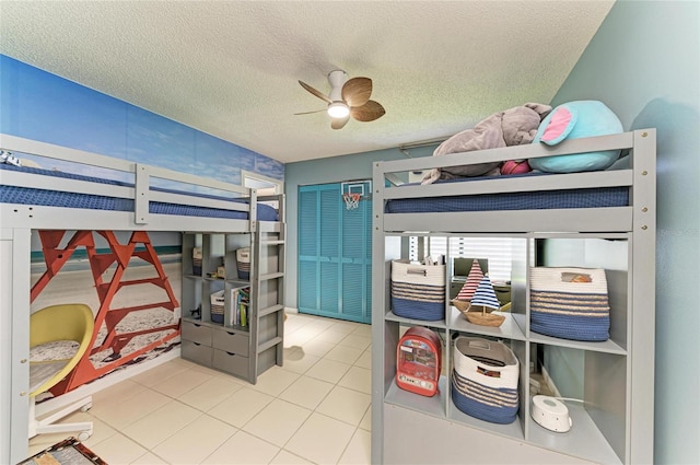 tiled bedroom featuring a ceiling fan and a textured ceiling