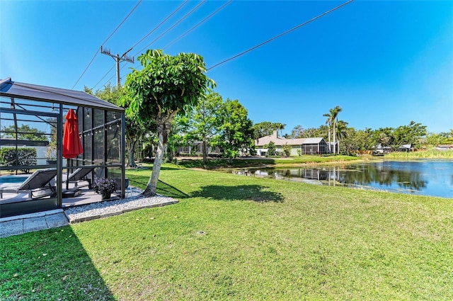 view of yard featuring a patio, a water view, glass enclosure, and a pool