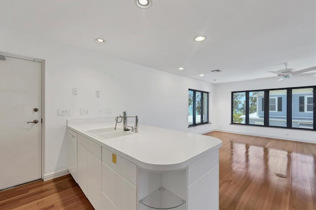 2918 Avenue Ave E, Holmes Beach, FL 34217 - kitchen featuring a peninsula, light countertops, wood finished floors, recessed lighting, and white cabinets
