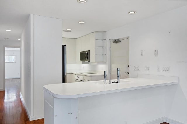 2918 Avenue Ave E, Holmes Beach, FL 34217 - kitchen with a peninsula, dark wood-style flooring, white cabinetry, light countertops, and recessed lighting