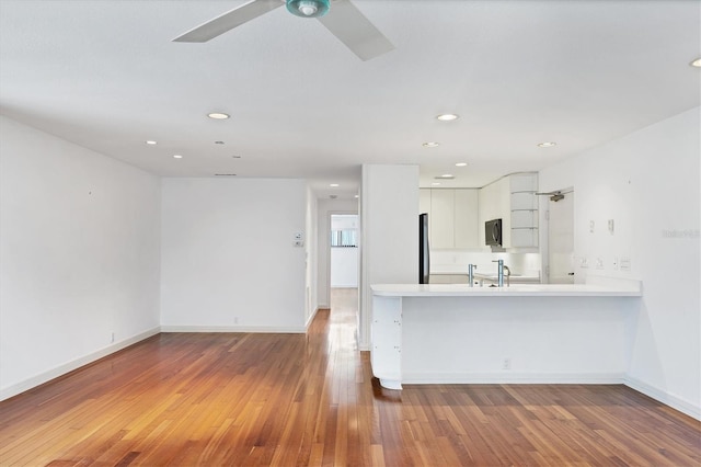 2918 Avenue Ave E, Holmes Beach, FL 34217 - kitchen with white cabinetry, light countertops, wood finished floors, a ceiling fan, and recessed lighting