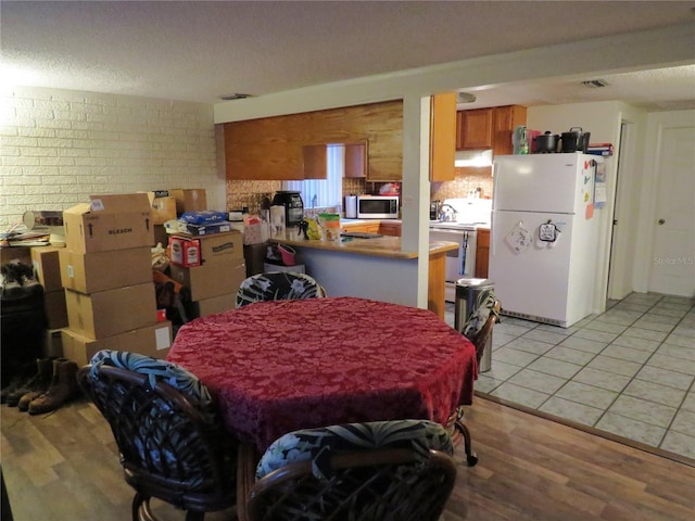 9835 El Camino Real Ave, Port Richey, FL 34668 - dining room with light wood-style flooring and a textured ceiling