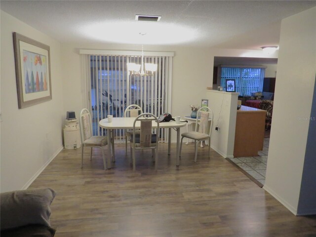 9835 El Camino Real Ave, Port Richey, FL 34668 - dining room with a chandelier, wood finished floors, and baseboards