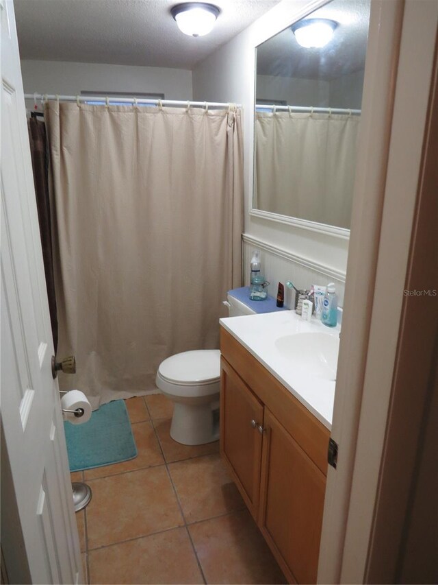 9835 El Camino Real Ave, Port Richey, FL 34668 - bathroom featuring vanity, toilet, tile patterned flooring, curtained shower, and a textured ceiling