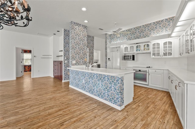 4180 Via Mirada, Sarasota, FL 34238 - kitchen featuring appliances with stainless steel finishes, light countertops, ceiling fan, light wood-style flooring, and glass insert cabinets