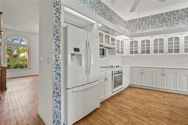 4180 Via Mirada, Sarasota, FL 34238 - kitchen with stainless steel appliances, baseboards, light wood-type flooring, and glass insert cabinets