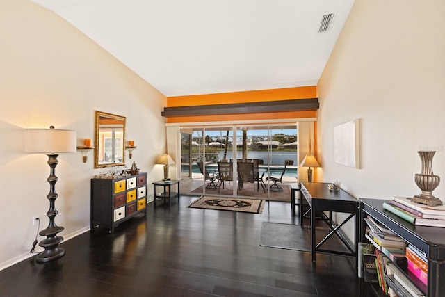 interior space featuring visible vents, vaulted ceiling, wood finished floors, baseboards, and a water view