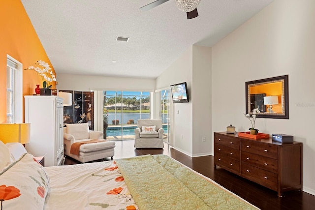 bedroom featuring access to outside, a textured ceiling, and dark wood-type flooring