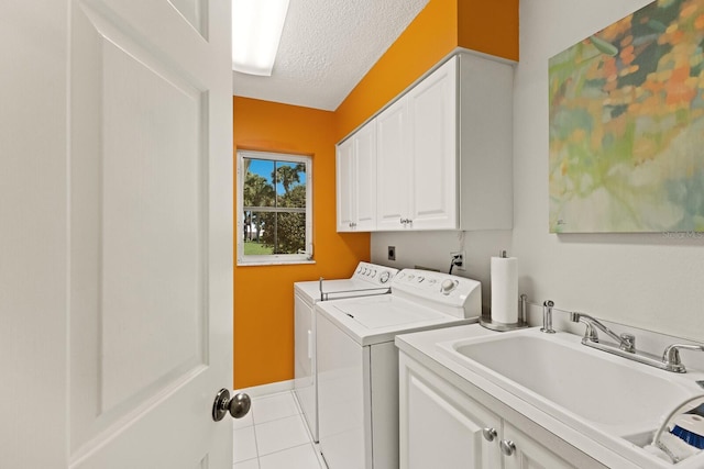 clothes washing area featuring cabinet space, independent washer and dryer, a textured ceiling, and a sink