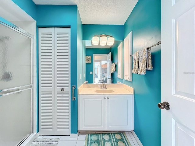 bathroom with vanity, tile patterned flooring, a closet, and a stall shower
