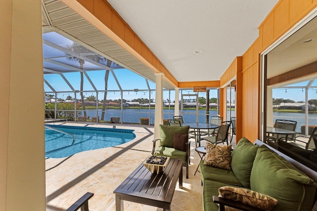 pool with a patio, a water view, and glass enclosure