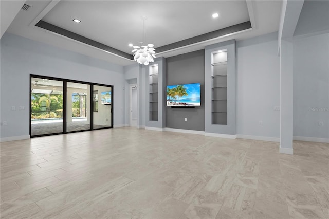 8229 Grande Shores Dr, Sarasota, FL 34240 - unfurnished living room with a raised ceiling, baseboards, a chandelier, built in features, and recessed lighting