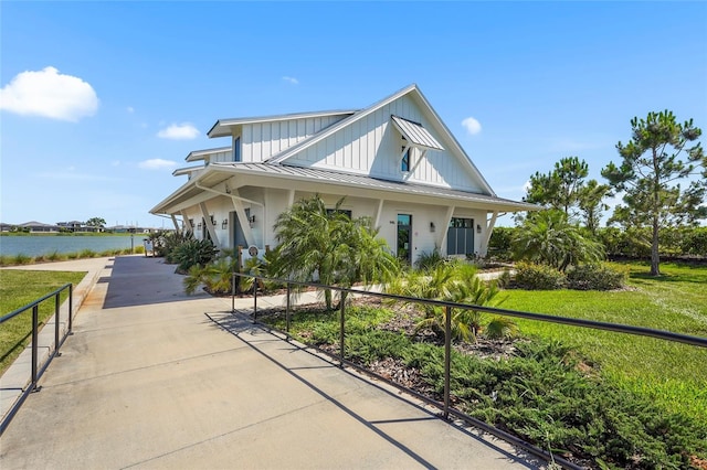 8229 Grande Shores Dr, Sarasota, FL 34240 - view of front of property with a standing seam roof, board and batten siding, a water view, and metal roof