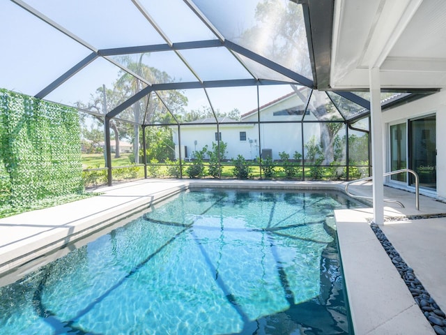 pool featuring glass enclosure and a patio area