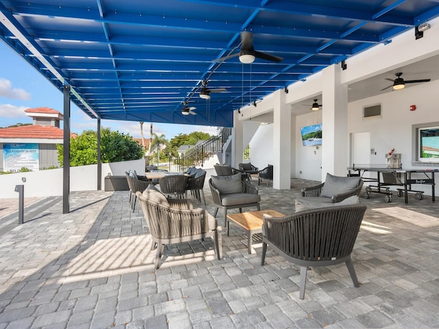 view of patio featuring stairway, ceiling fan, an outdoor living space, and outdoor dining area