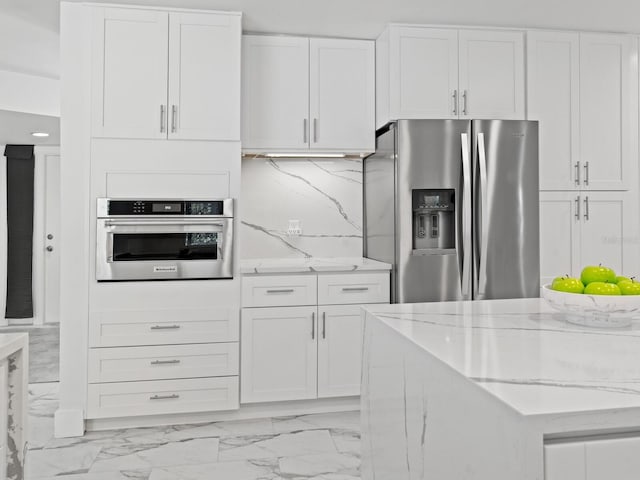 172 Sea Anchor Dr, Osprey, FL 34229 - kitchen with appliances with stainless steel finishes, light stone counters, white cabinets, and light marble finish floors