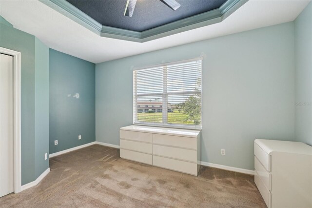 2353 Rosewood Ln, North Port, FL 34289 - unfurnished bedroom featuring light colored carpet, a raised ceiling, baseboards, and a ceiling fan