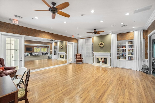 2353 Rosewood Ln, North Port, FL 34289 - living room featuring crown molding, a glass covered fireplace, a ceiling fan, light wood-style floors, and recessed lighting