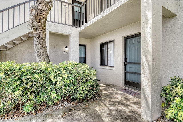 7876 Eagle Creek Dr, Sarasota, FL 34243 - entrance to property featuring stucco siding and a balcony