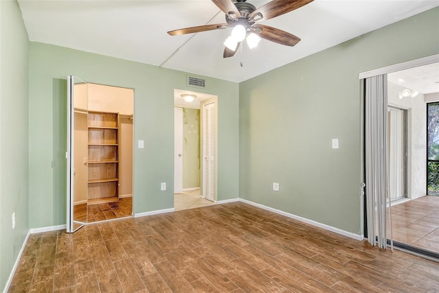 7876 Eagle Creek Dr, Sarasota, FL 34243 - unfurnished bedroom with wood finished floors, baseboards, and a ceiling fan