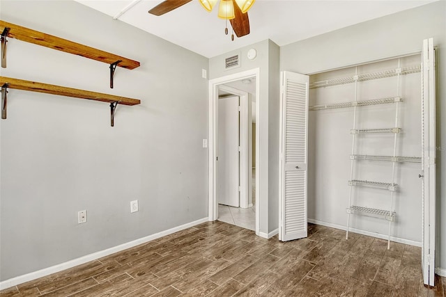7876 Eagle Creek Dr, Sarasota, FL 34243 - unfurnished bedroom featuring wood finished floors, baseboards, a closet, and ceiling fan