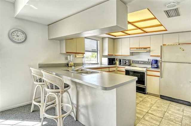 7876 Eagle Creek Dr, Sarasota, FL 34243 - kitchen featuring white appliances, a sink, under cabinet range hood, a peninsula, and a breakfast bar area