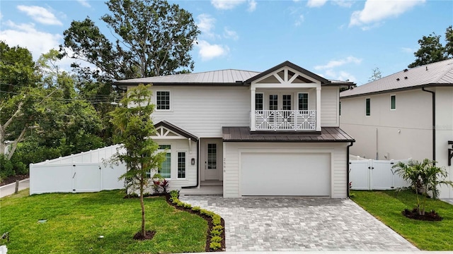 2596 Floyd St, Sarasota, FL 34239 - view of front of home with a balcony, a gate, metal roof, a standing seam roof, and decorative driveway