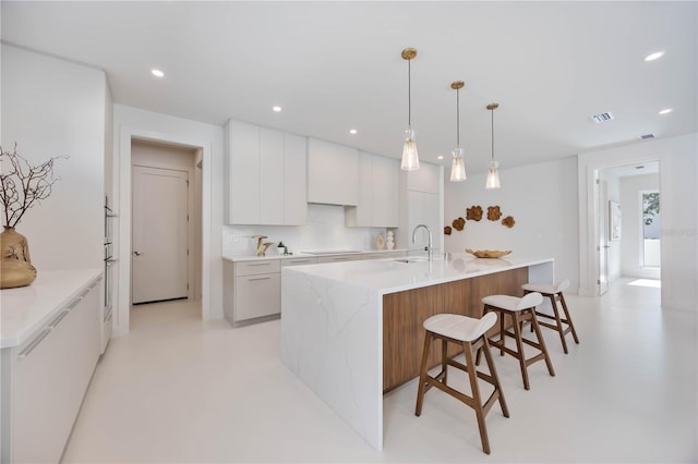 2596 Floyd St, Sarasota, FL 34239 - kitchen with modern cabinets, white cabinetry, a breakfast bar, decorative light fixtures, and a sink