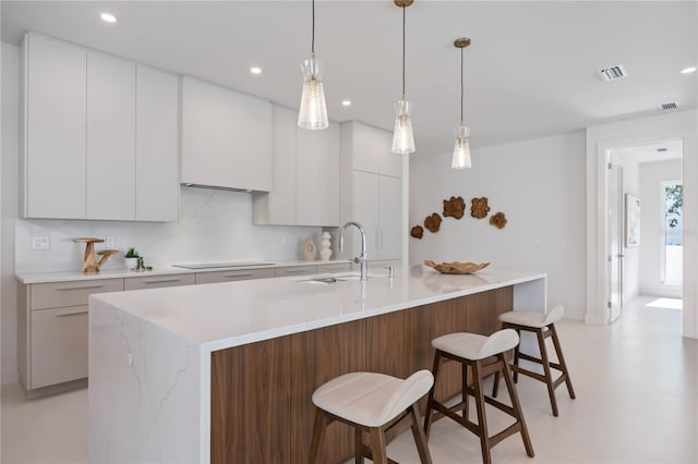 2596 Floyd St, Sarasota, FL 34239 - kitchen featuring a sink, modern cabinets, black electric cooktop, a breakfast bar area, and recessed lighting
