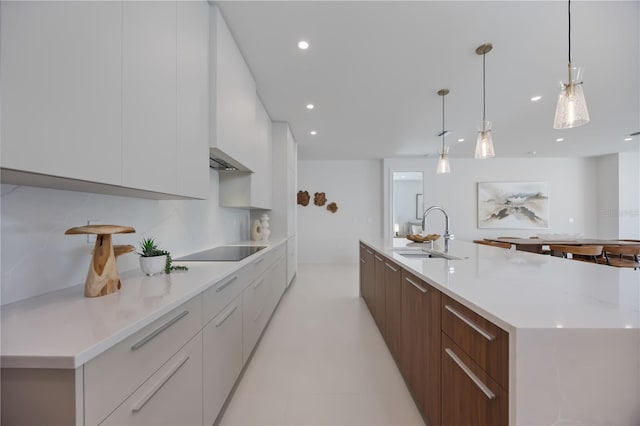 2596 Floyd St, Sarasota, FL 34239 - kitchen with a sink, modern cabinets, black electric cooktop, white cabinetry, and light countertops