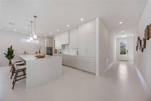 2596 Floyd St, Sarasota, FL 34239 - kitchen with modern cabinets, white cabinetry, a kitchen breakfast bar, a kitchen island, and recessed lighting