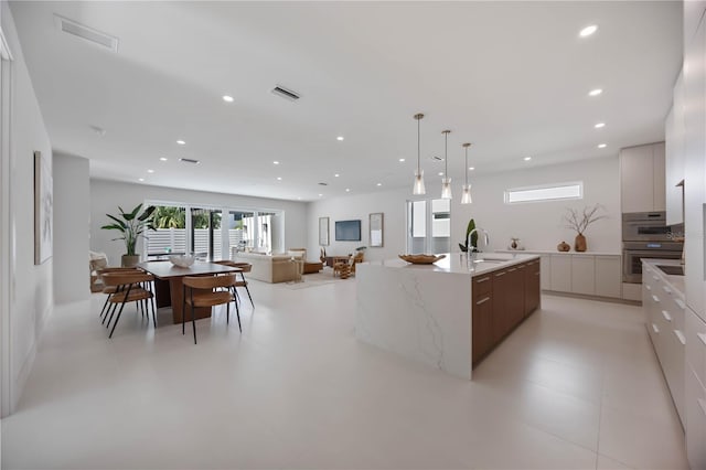 2596 Floyd St, Sarasota, FL 34239 - kitchen with modern cabinets, a sink, recessed lighting, a large island, and light stone counters