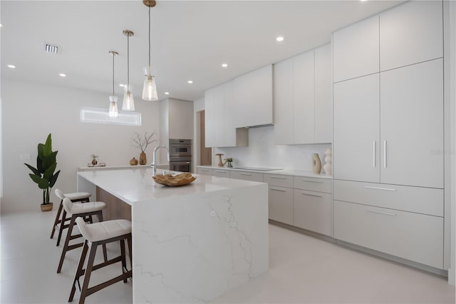 2596 Floyd St, Sarasota, FL 34239 - kitchen with a kitchen breakfast bar, black electric stovetop, double oven, modern cabinets, and white cabinets