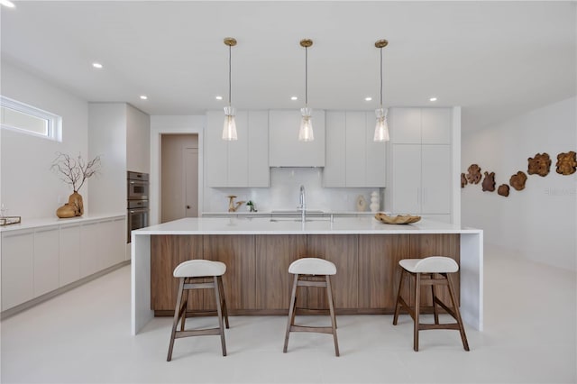 2596 Floyd St, Sarasota, FL 34239 - kitchen with modern cabinets, white cabinetry, a kitchen breakfast bar, light countertops, and double oven