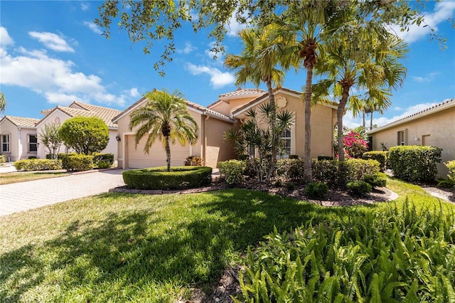 6519 43rd Ct E, Sarasota, FL 34243 - mediterranean / spanish house with a front lawn, stucco siding, driveway, and a garage