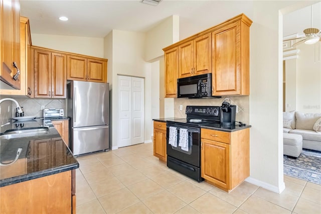 6519 43rd Ct E, Sarasota, FL 34243 - kitchen with a sink, decorative backsplash, black appliances, and light tile patterned floors
