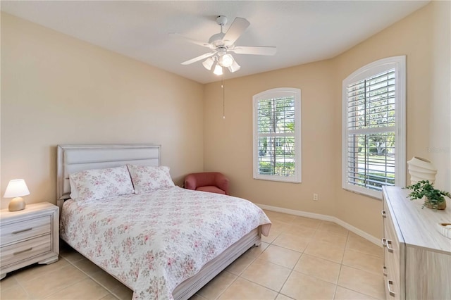 6519 43rd Ct E, Sarasota, FL 34243 - bedroom with baseboards, light tile patterned flooring, and ceiling fan