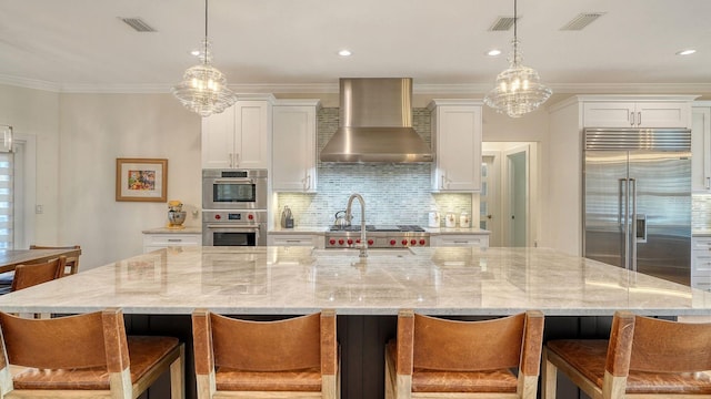 345 Madison Dr, Sarasota, FL 34236 - kitchen with visible vents, wall chimney exhaust hood, a spacious island, stainless steel appliances, and white cabinetry