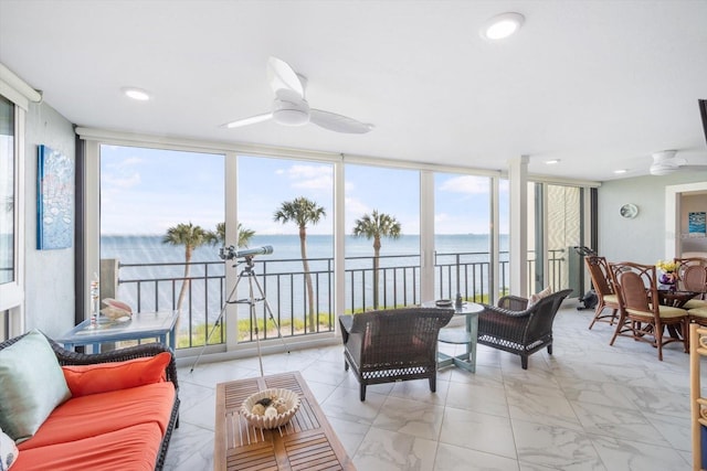 sunroom / solarium featuring a wall of windows, a water view, and marble finish floor