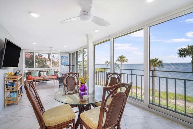 sunroom / solarium featuring a water view, recessed lighting, expansive windows, and marble finish floor